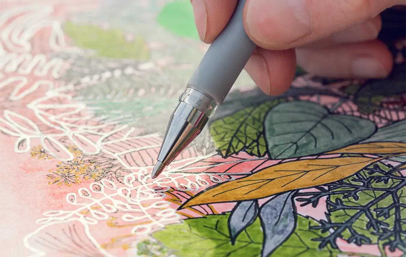 Main de Maria José Martinez apportant les derniers détails à une œuvre originale florale réalisée sur papier.