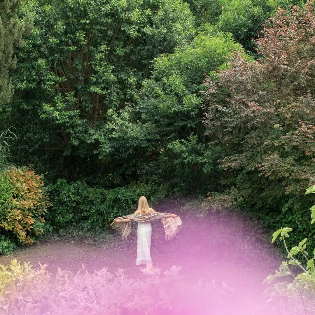 Maria José Martinez marchant, bras ouverts, dans un paysage naturel qui nourrit son inspiration artistique.