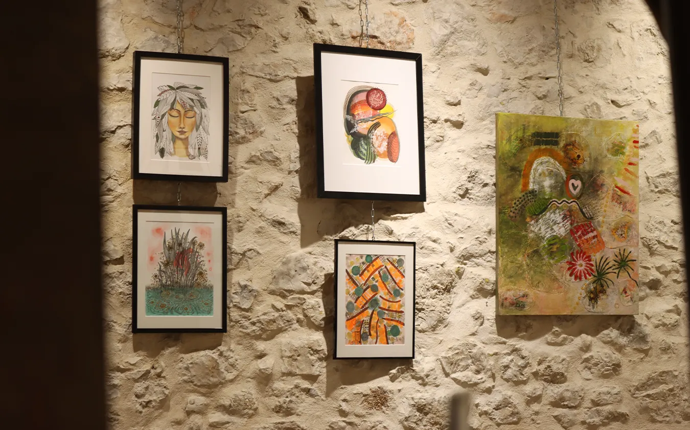 Œuvres originales de Maria José Martinez exposées sur un mur de pierre dans une abbaye.